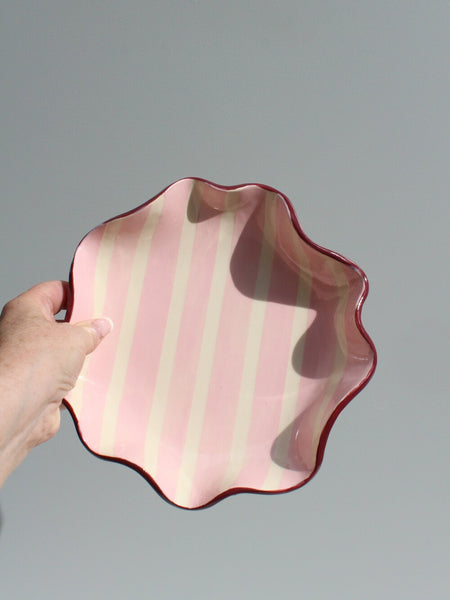 Pink and burgundy ruffle bowl with hand for scale
