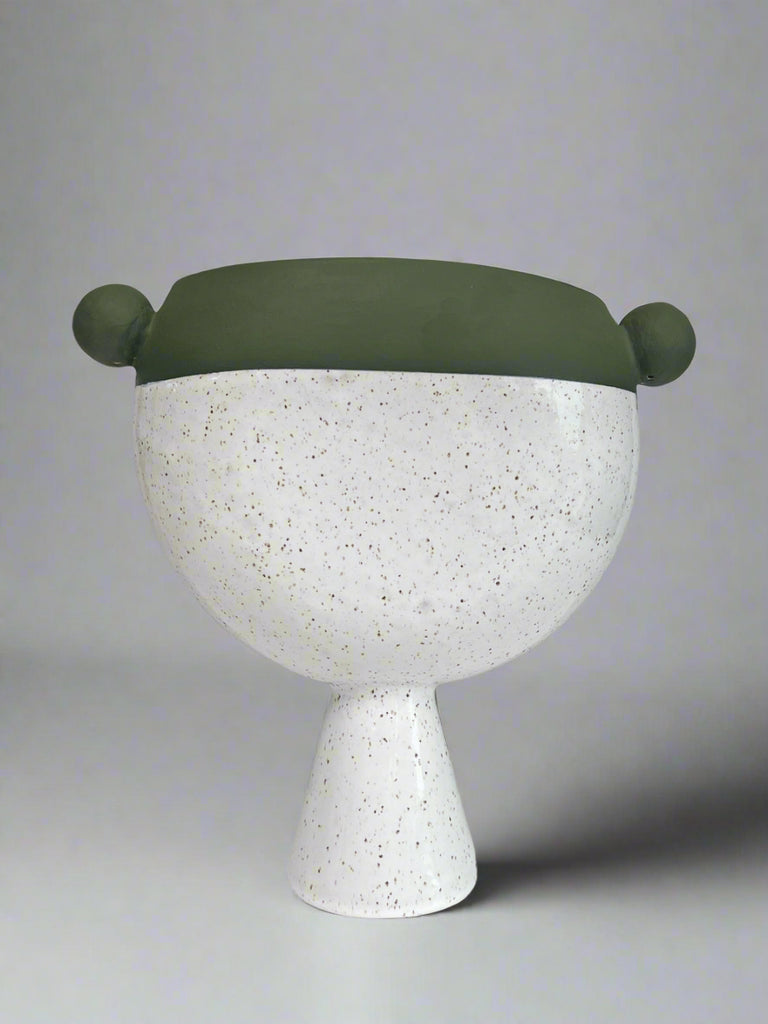 Decorative vase with a green top and white speckled base on a gray background