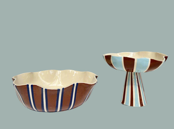 Two ceramic bowls with striped patterns on a white surface and gray background