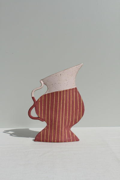 Ceramic jug with a striped design on a plain background