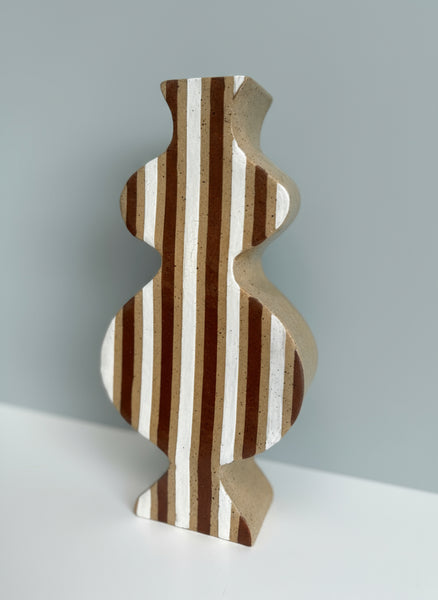 Decorative vase with wavy design and striped pattern on a light gray background