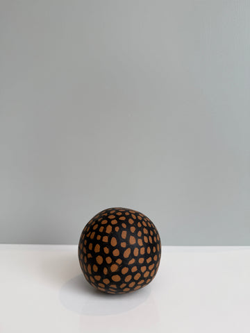 Decorative sphere with brown spots on a gray background