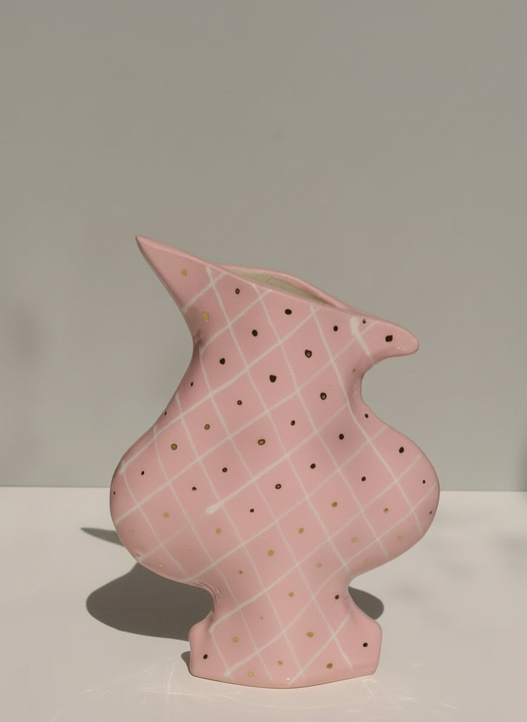 Pink ceramic vase with a textured pattern on a plain background