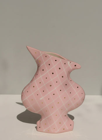 Pink ceramic vase with a textured pattern on a plain background