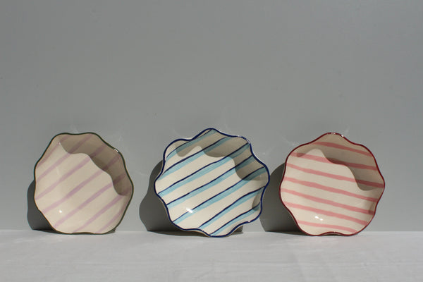 Three ceramic bowls with striped patterns on a gray background