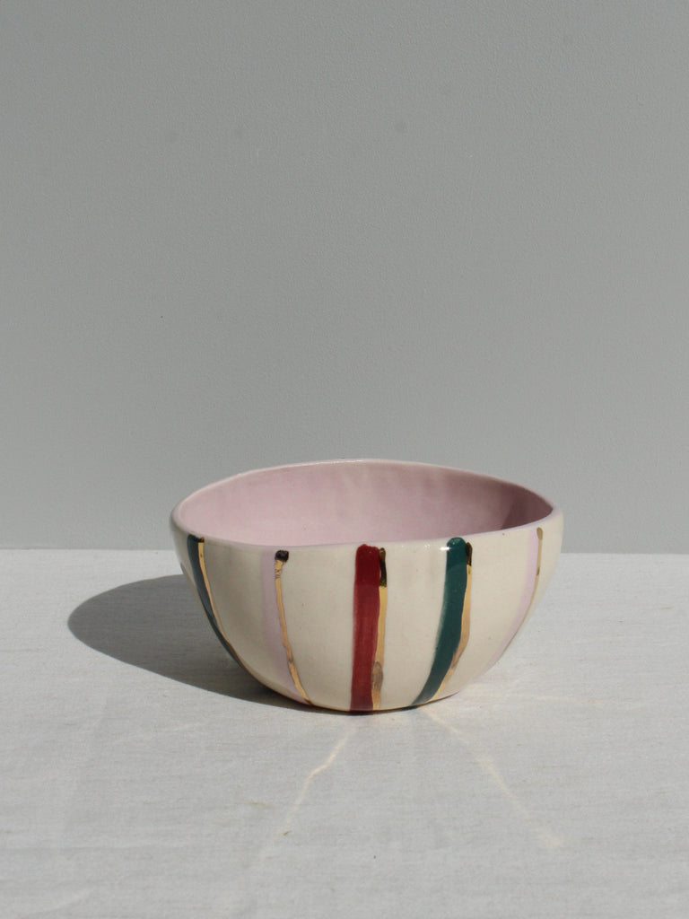 Ceramic bowl with colorful stripes on a light gray background