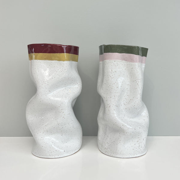 Two unique ceramic vases with color-blocked tops on a plain background