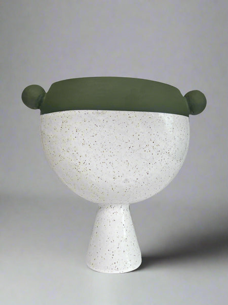 Decorative vase with a green top and white speckled base on a gray background