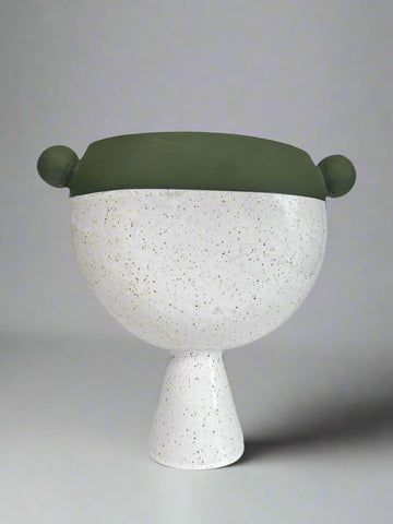 Decorative vase with a green top and white speckled base on a gray background