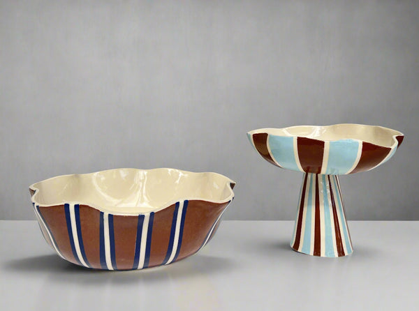 Two ceramic bowls with striped patterns on a white surface and gray background